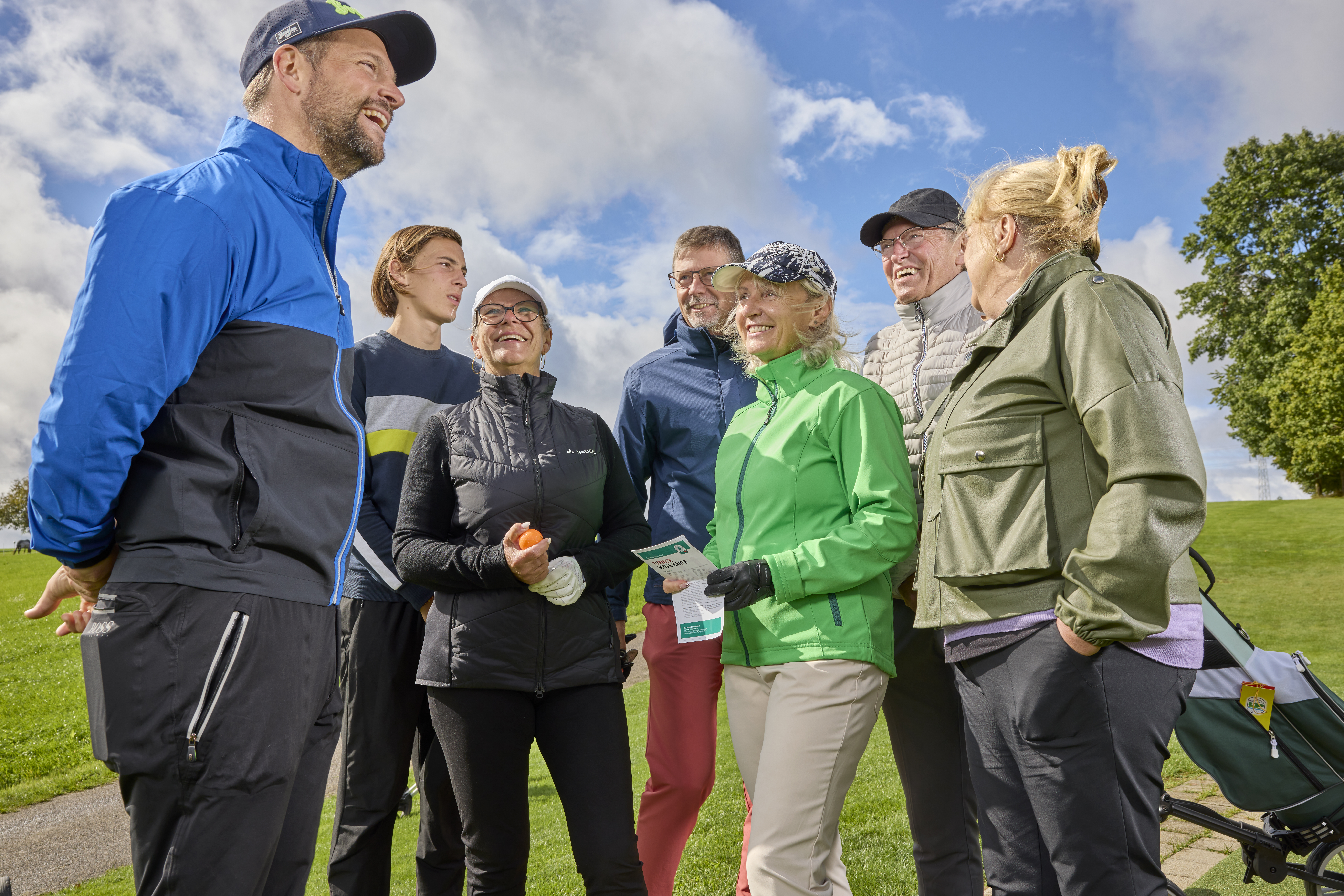 Sieben Personen auf dem Golfplatz bei Sonnenschein