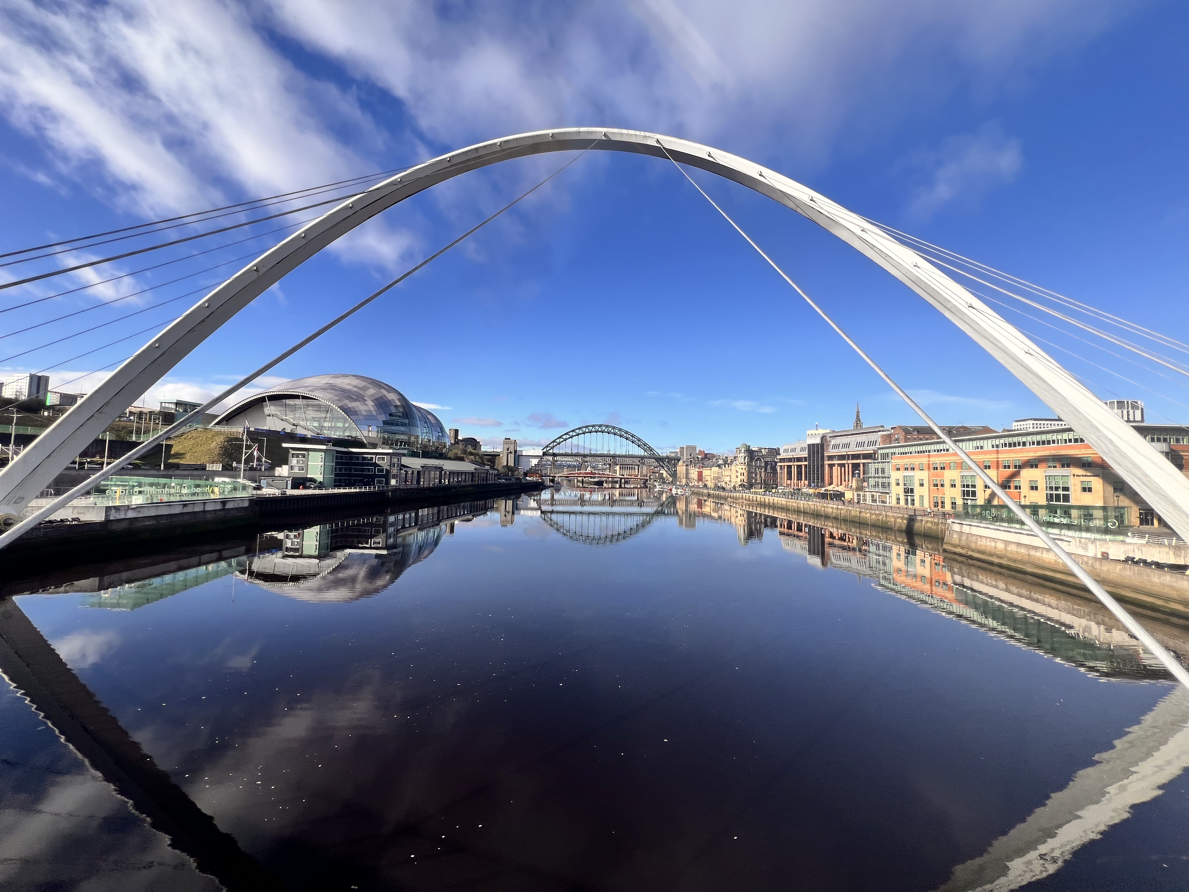 Eine Skulptur, die sich über einen Fluss in einer Stadt spannt